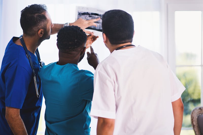 Medical team examining orthopedic X-ray images for surgical planning